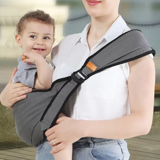 Porte bebe hanche gris enfant sur la hanche de maman sourit