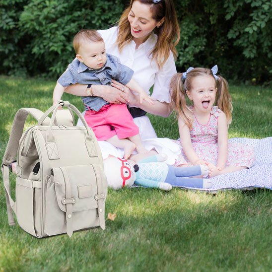 sac à dos à langer beige maman avec deux enfants en pique-nique