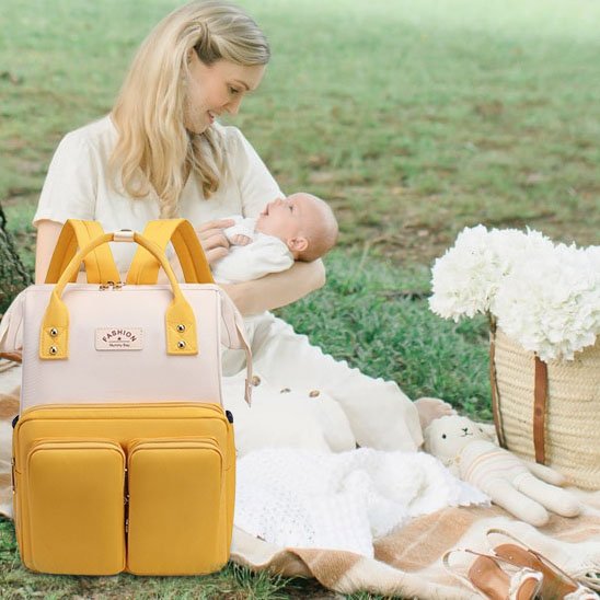 Sac à dos à langer jaune canari et rose et maman avec son bébé en pique nique