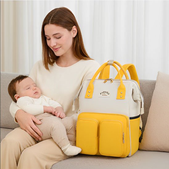 Sac a langer jaune canari et bébé assis sur sa maman