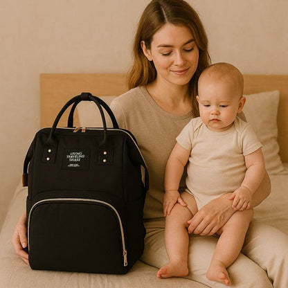 Sac a langer noir posé sur lit davant maman et son bébé