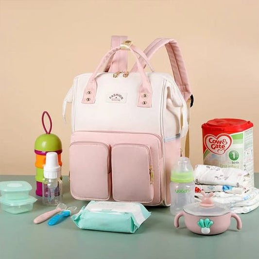 Sac a langer rose à plusieurs poches avec different produits bébé