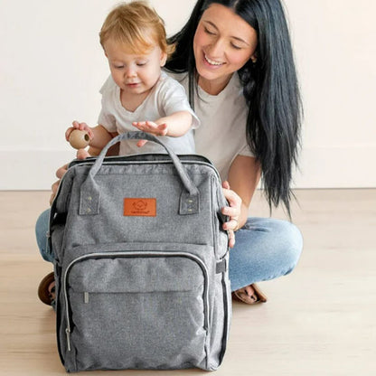 maman assise avec enfant sac a langer gris pose devant