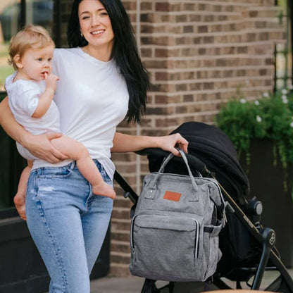 maman en sortie avec bebe pousse poussette sac a langer gris accroche
