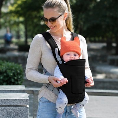 Porte bebe noir sur maman qui marche